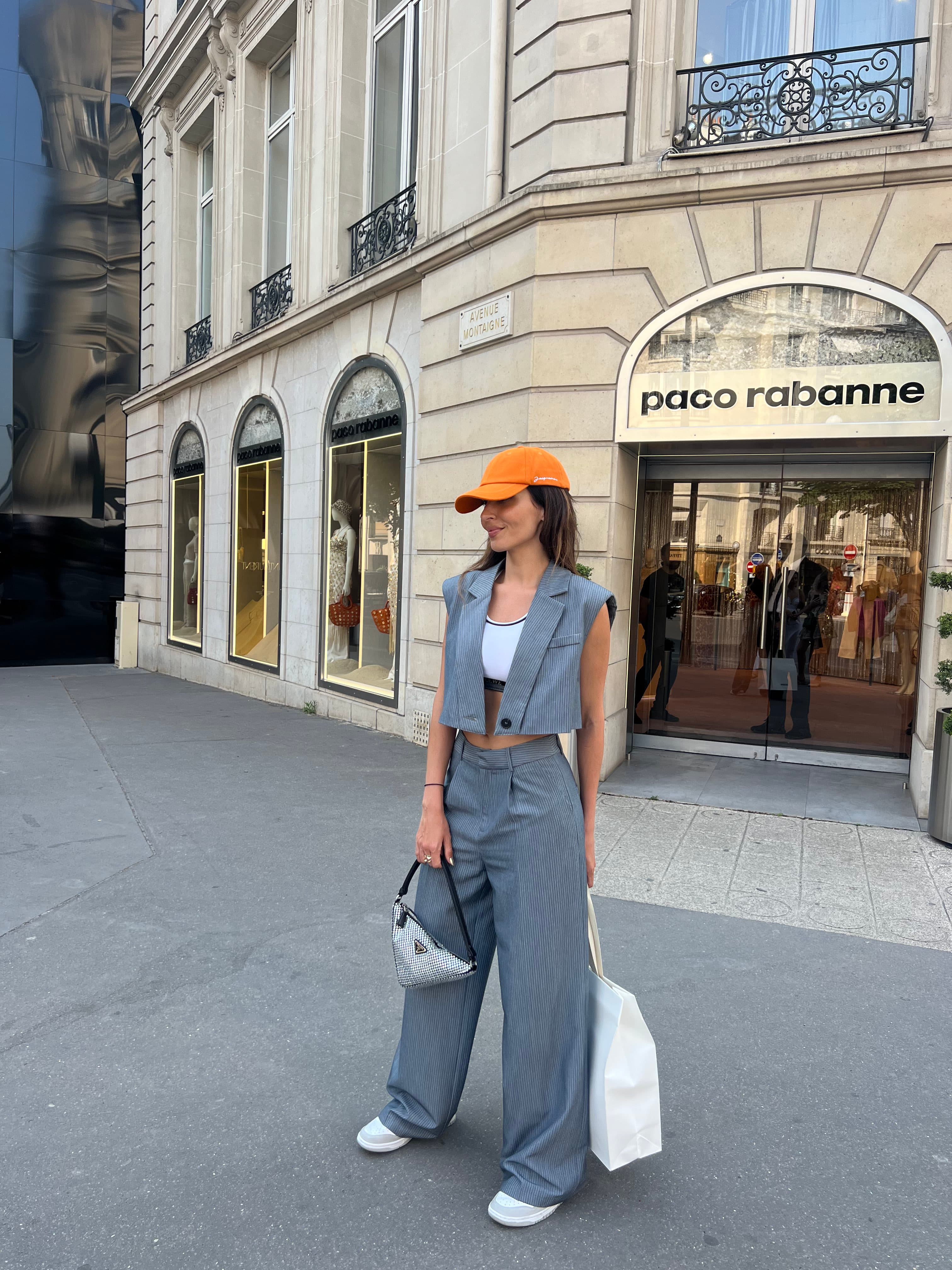 Woman posing outside of store.